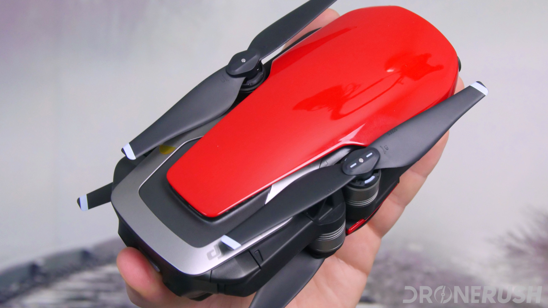 Image of a red DJI Mavic Air folded and held in hand. Let's talk about things to do with your DJI Mavic Air.